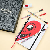 Blackwing Volume 292 Keith Haring gift set featuring a notebook with Haring’s smiling heart illustration, 4 pencils, a sharpener, and a point guard.